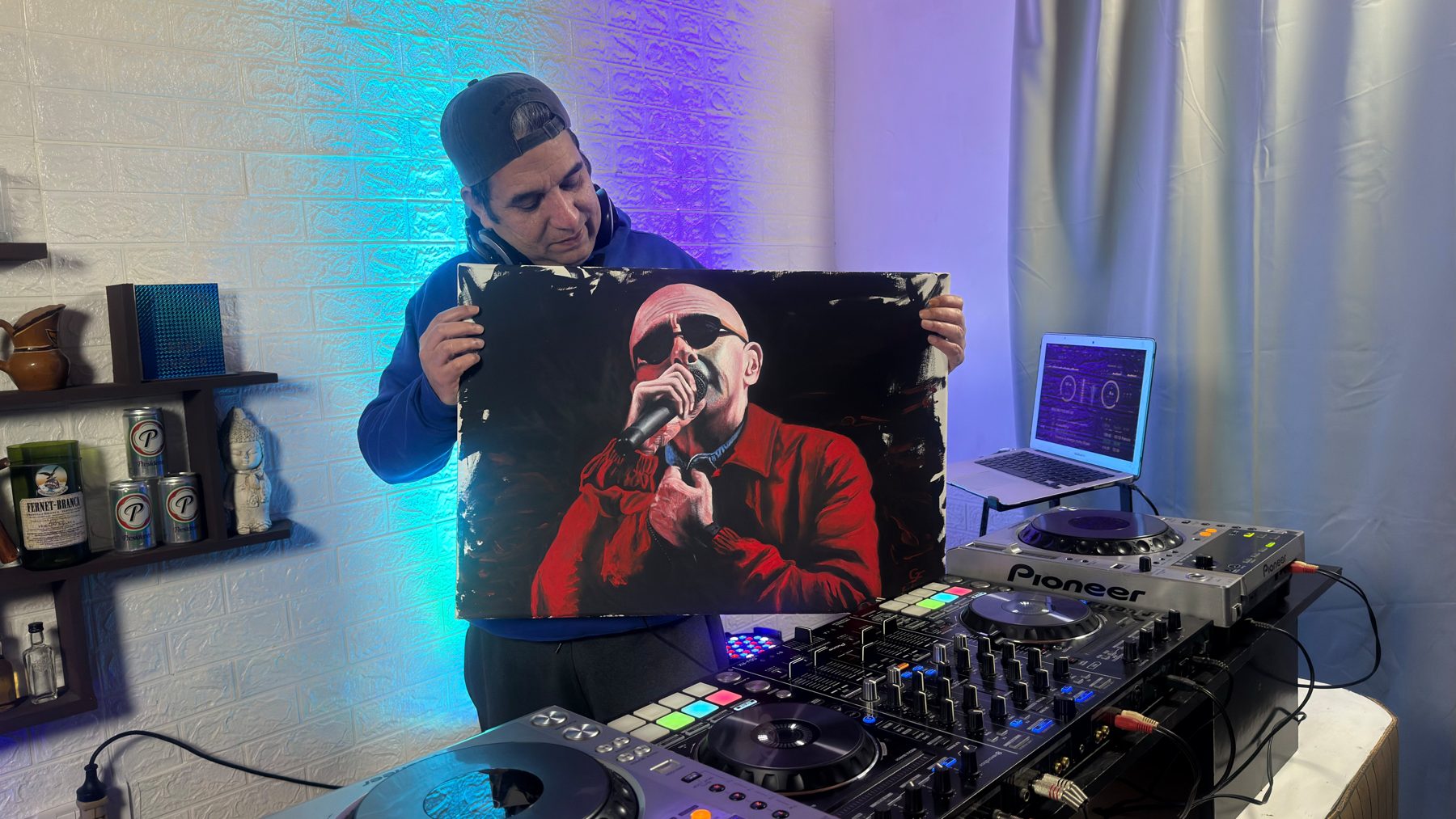 Gilberto Farías en la cabina de DJ con su retrato del Indio Solari